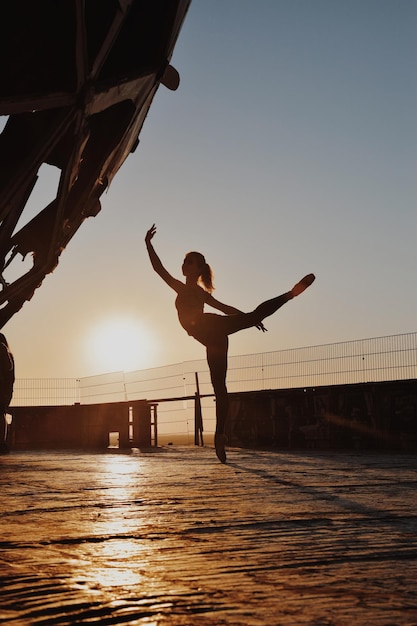 Foto silhouette di una ragazza adolescente che balla contro il cielo durante il tramonto