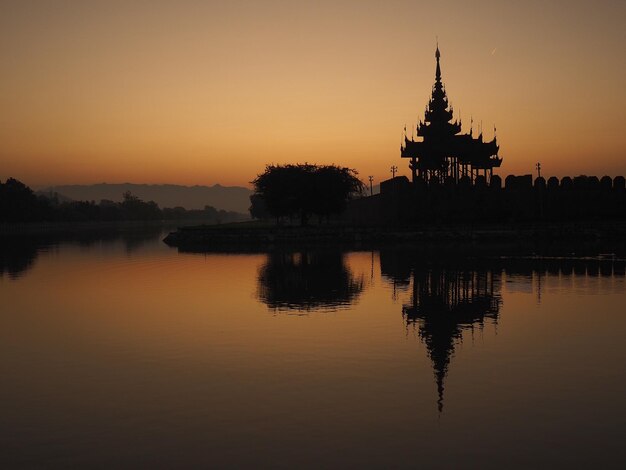 Foto silhouette del tempio sul lago contro il cielo durante il tramonto