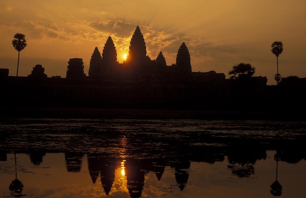 写真 夕暮れの空に反射する池のシルエット寺院