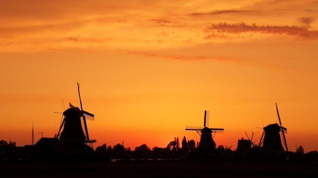 Silhouette of traditional windmill against sky during sunset