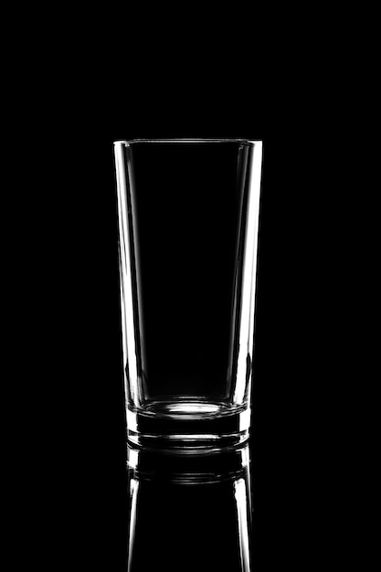 Silhouette of a transparent glass on a dark background with copy space