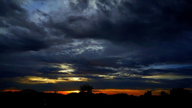 Photo silhouette trees against cloudy sky during sunset