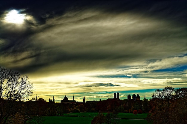 Photo silhouette of trees against cloudy sky