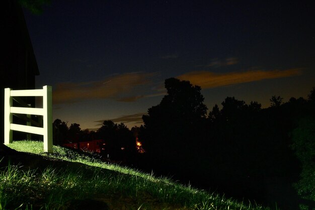 Silhouette trees on field against sky at sunset