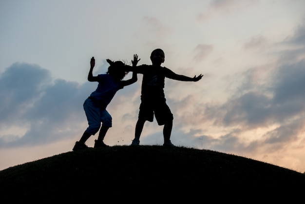 Silhouette of two brothers enjoying the freedom