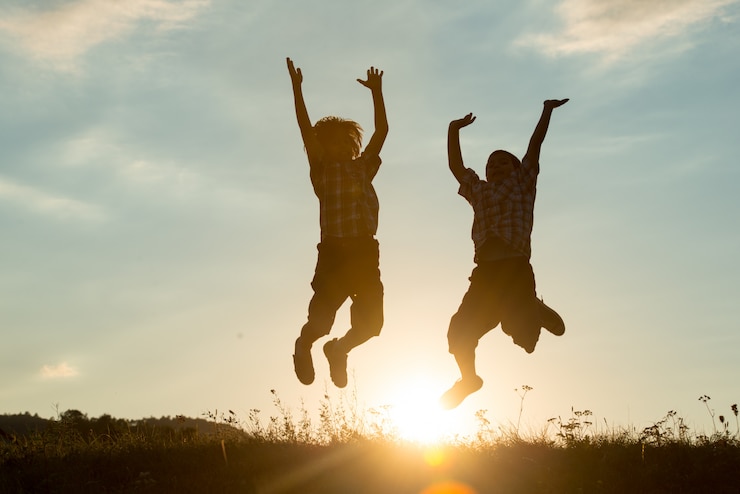 Photo silhouette of two brothers enjoying the freedom