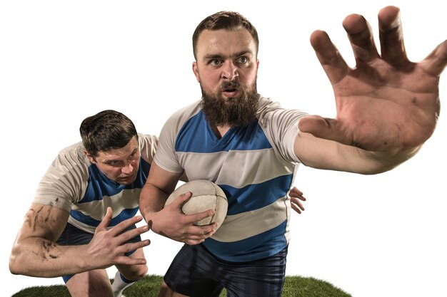 The silhouette of two caucasian rugby man players isolated on white background. Studio shot of fit man in motion or movement with ball. Game and action concept. Incredible strain of all forces