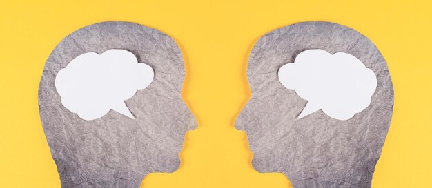 Silhouette of two faces, speech bubble in white color, copy space for text, communication