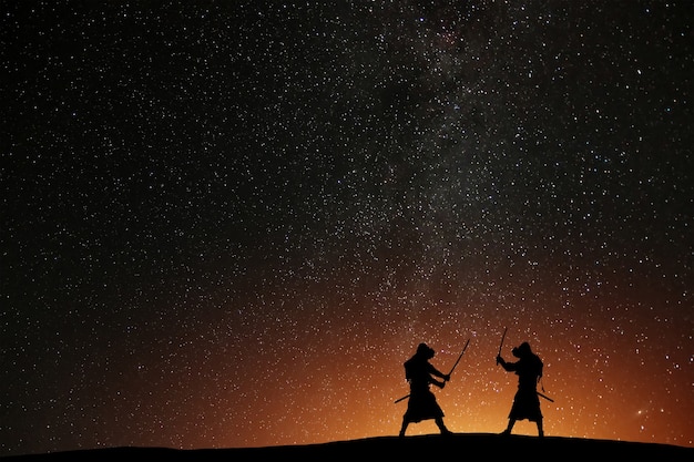 Silhouette of two samurais against the starry sky. Deadly warriors with swords