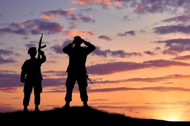 Silhouette of two soldiers on exploration at sunset