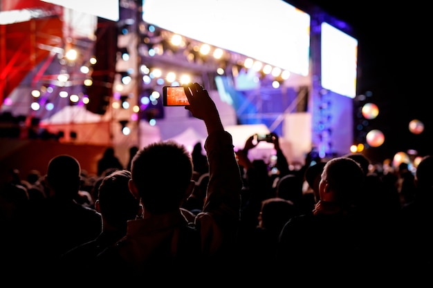 Foto silhouette di utilizzare un telefono cellulare a un concerto.