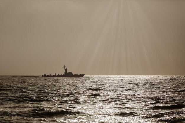 Silhouette of a warship at sunset black and white