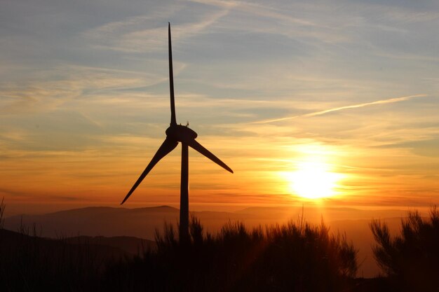 Foto silhouette di una turbina eolica contro il cielo durante il tramonto