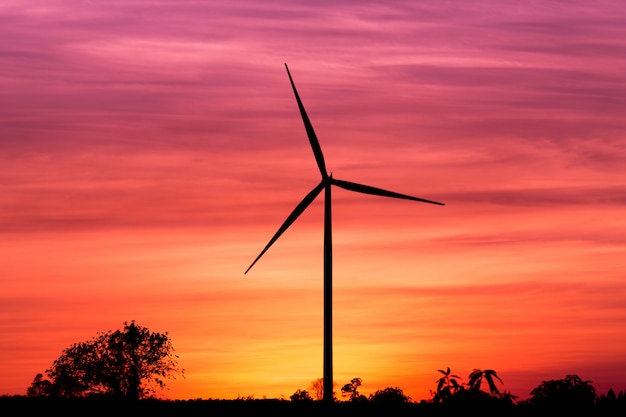 Generatore eolico della siluetta sul cielo di tramonto