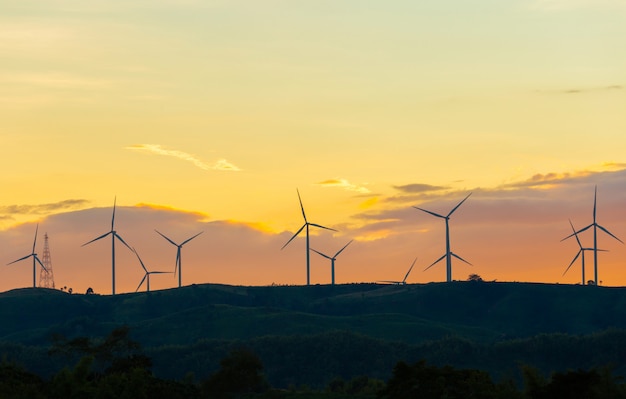 Silhouette of wind turbines at sunset in evening time, alternative energy