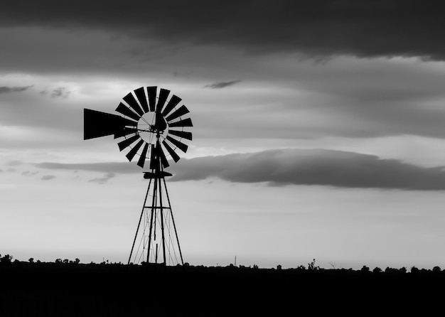 Силуэт ветряной мельницы на поле на фоне неба