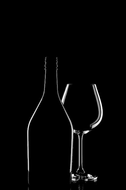 Foto silhouette di una bottiglia di vino e bicchiere di vino su sfondo nero