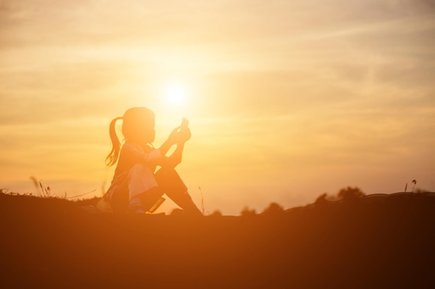 Foto silhouette di donna contro il cielo arancione