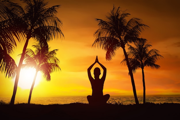 Photo silhouette of woman doing yoga with ocean view