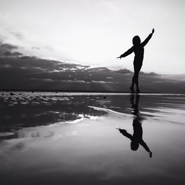 Foto silhouette donna che si esercita sulla spiaggia