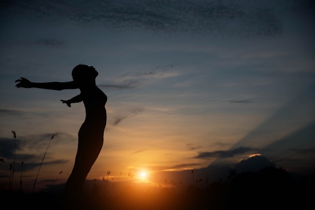 Silhouette donna felice e tramonto