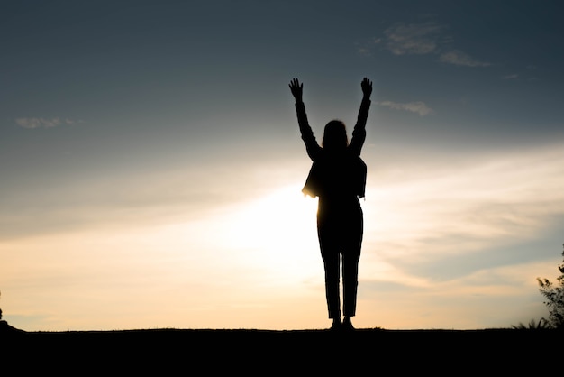 Silhouette woman happy at sunset