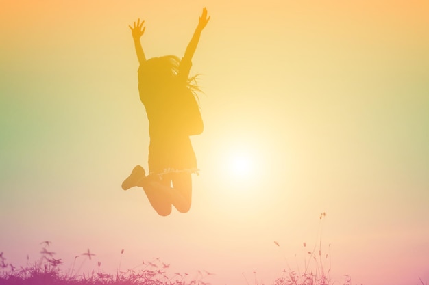 Photo silhouette woman jumping against sky during sunset