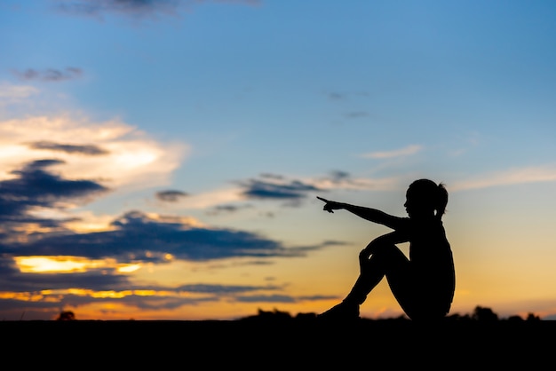 Silhouette of woman Looking for a dream at sunset