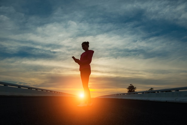 Silhouette of woman pointing with finger in sky