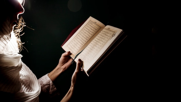 Photo silhouette of woman reading in quran