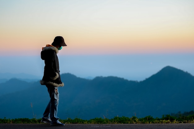 Silhouette woman sad on mountain in sunset and vintage filter