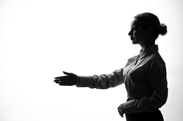 Silhouette of woman shaking hands side view shadow back lit young