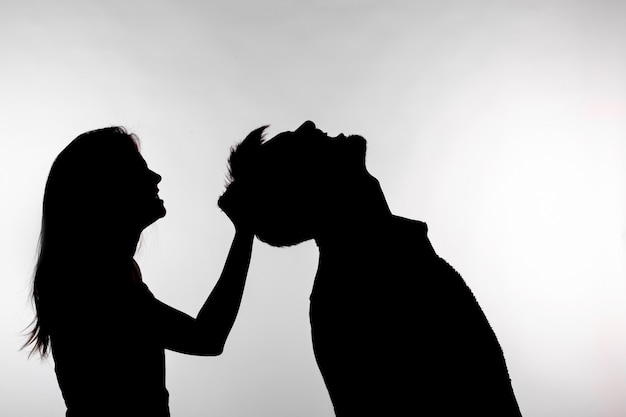 Silhouette of a woman slapping a man.