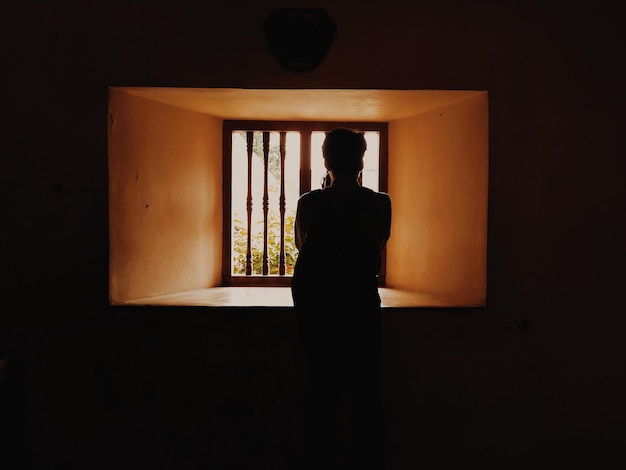 silhouette woman standing against window