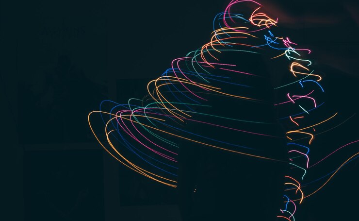 Photo silhouette woman standing amidst colorful light painting in dark