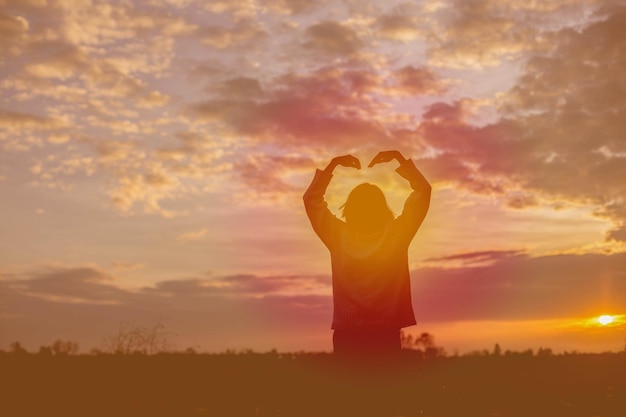 Foto silhouette donna in piedi sul campo contro il cielo durante il tramonto