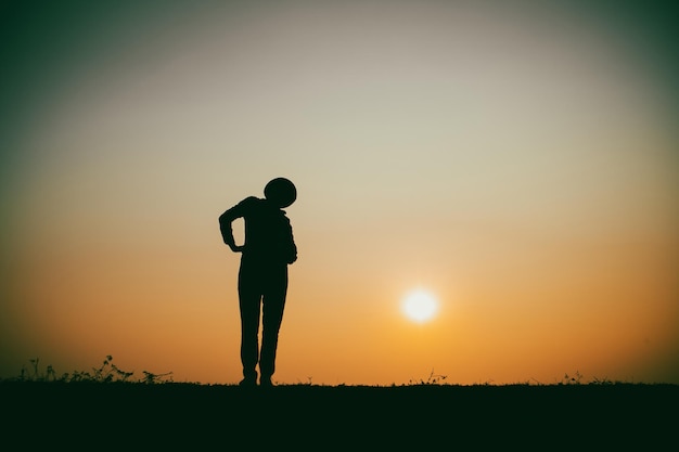 아름다운 일몰 동안 강가에 외롭게 서 있는 여성의 실루엣