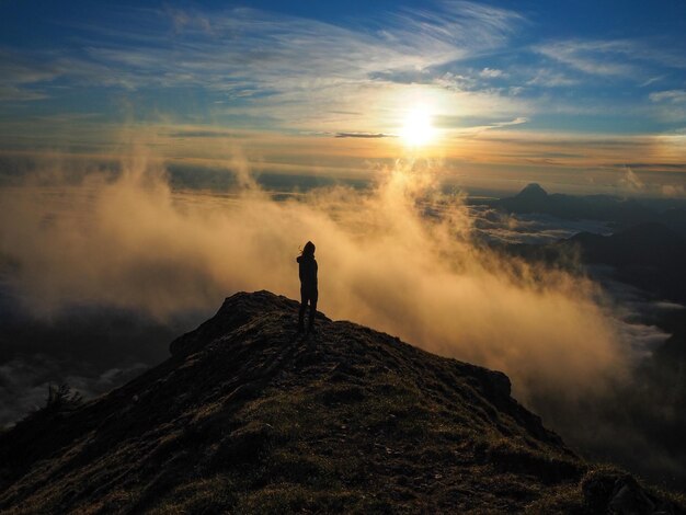 Foto silhouette donna in piedi su una montagna contro il cielo al mattino.