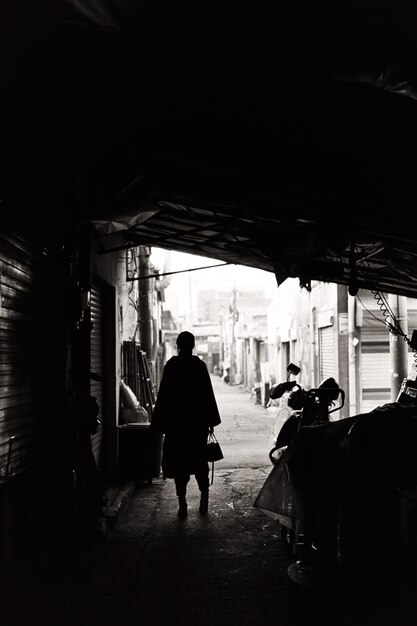 Silhouette woman standing on street in city