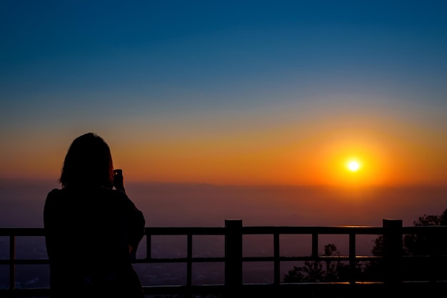 태국 치앙마이 DOI SUTHEP 산 전망대에서 일출 때 카메라로 사진을 찍는 여성의 실루엣