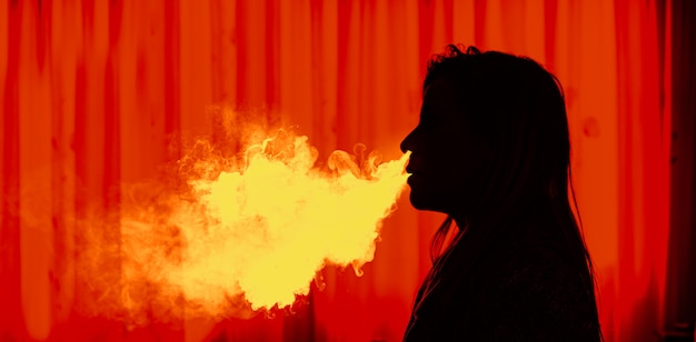 Silhouette of Woman vaping an electronic cigarette