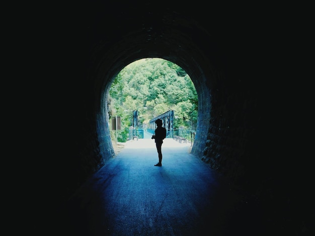 Photo silhouette woman walking in tunnel