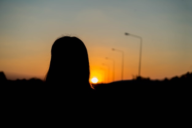 Silhouette of a woman with evening sky.