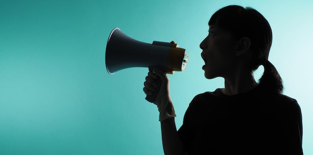 Photo the silhouette of the woman with the hand is holding megaphone on green or mint or tiffany blue backgroundx9