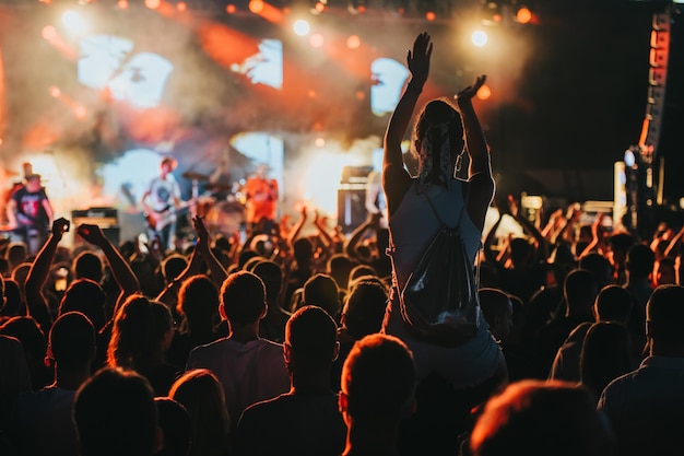 Silhouette of a woman with raised hands on a concert