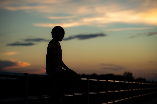 Silhouette woman with sadness at sunset alone.