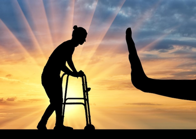 身体障害者用歩行器と手振り停止の女性のシルエット。障害者と老後の差別と軽蔑の概念