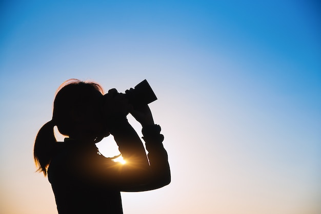 Silhouette of women taking pictures.