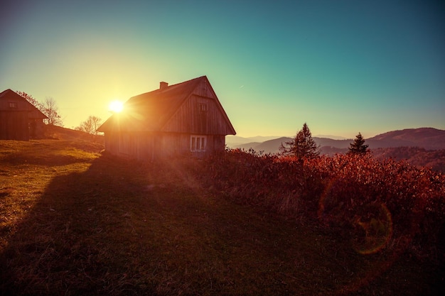 Silhouette of a wooden hut in the early sunny morning Carpathian mountains Ukraine