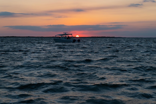 Silhouette of yacht boat. Seascape sundown. Nature concept. Beautiful twilight. summer vacation. Early morning sunrise over sea. Ocean sunset on sea water with sunset sky.